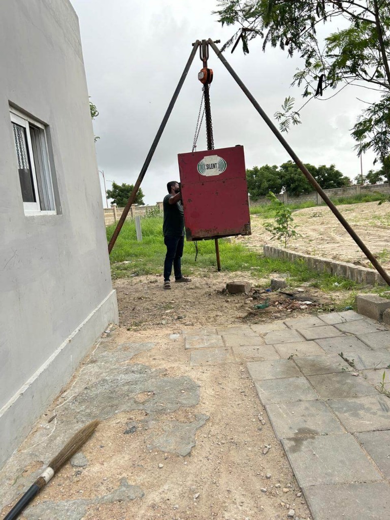 Generator being lifted by a crane at a property