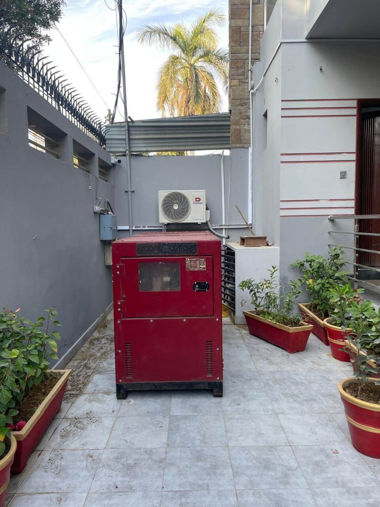 Red generator installed in a home courtyard
